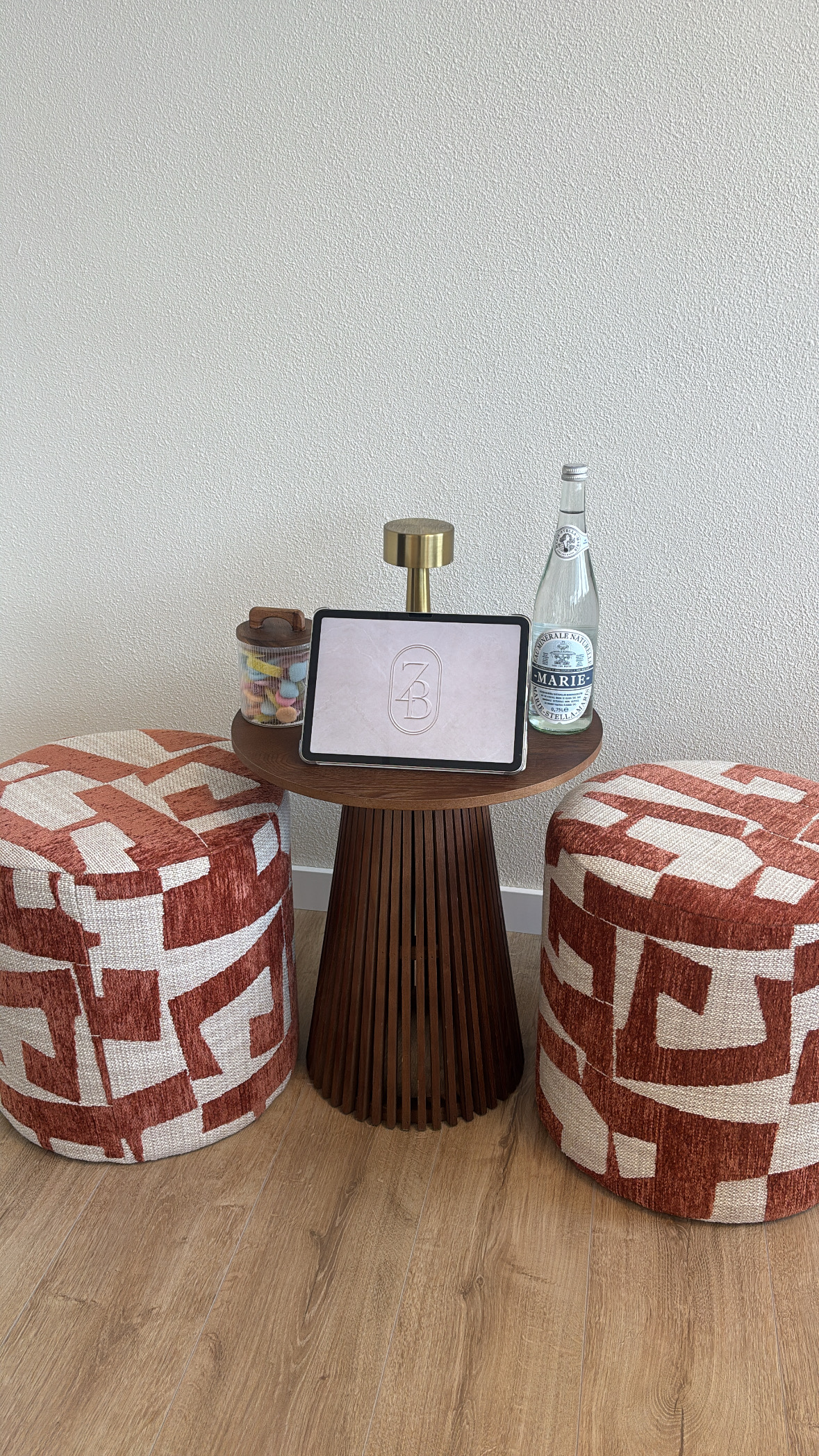 De wachthoek in de salon met twee poefs en een walnoten bijzettafel