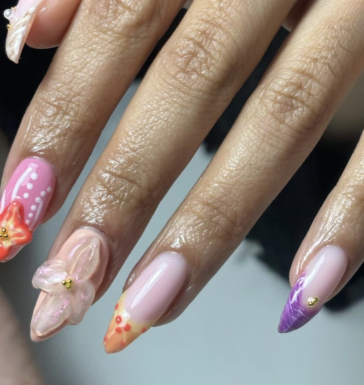 Lange amandelnagels met 3D bloemen, roze en paarse nail art